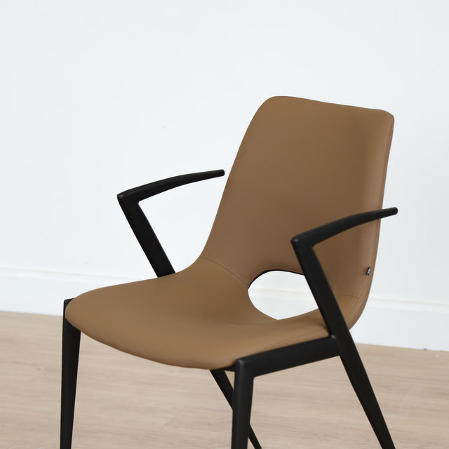 Chaise design en cuir végane Delta avec piètement noir et accoudoirs intégrés, idéale pour salle à manger moderne.