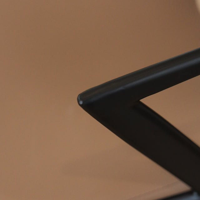 Chaise design en cuir végane Delta avec piètement noir et accoudoirs intégrés, idéale pour salle à manger moderne.