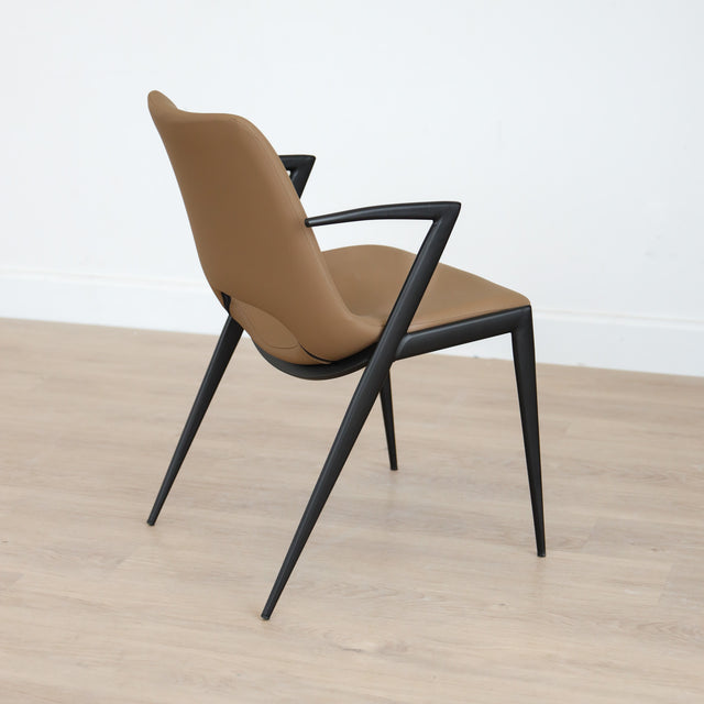 Chaise design en cuir végane Delta avec piètement noir et accoudoirs intégrés, idéale pour salle à manger moderne.