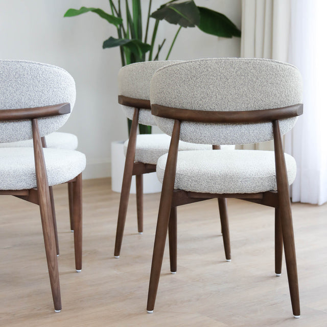 Chaises de salle à manger en tissu bouclé ivoire avec pattes en noyer foncé, style scandinave moderne.