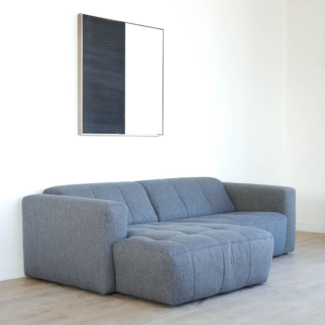 Modulaire deux places en tissu gris foncé avec chaise longue gauche, design moderne et lignes épurées pour salon contemporain.