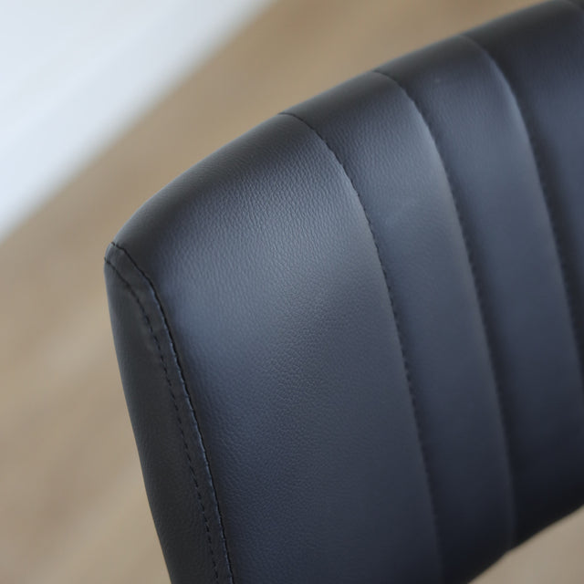 Lot de trois chaises de salle à manger noires en cuir végane noir avec piètement en métal noir, style moderne minimaliste.