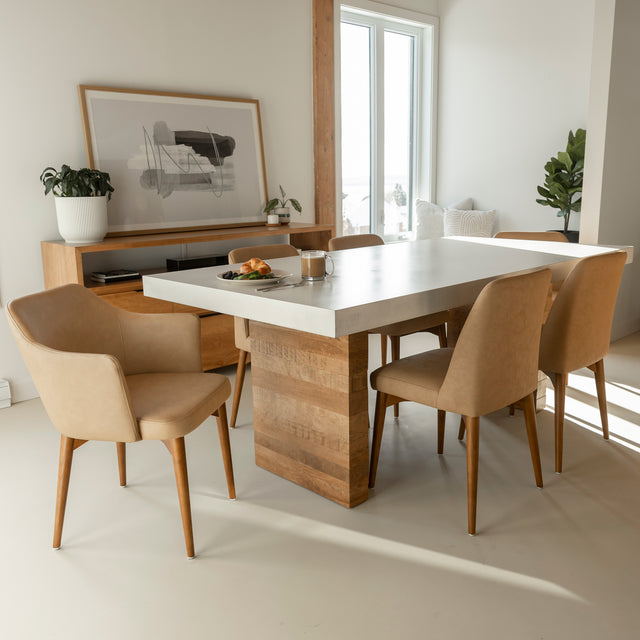 table de salle a manger en beton clair avec base en bois et chaises beige.