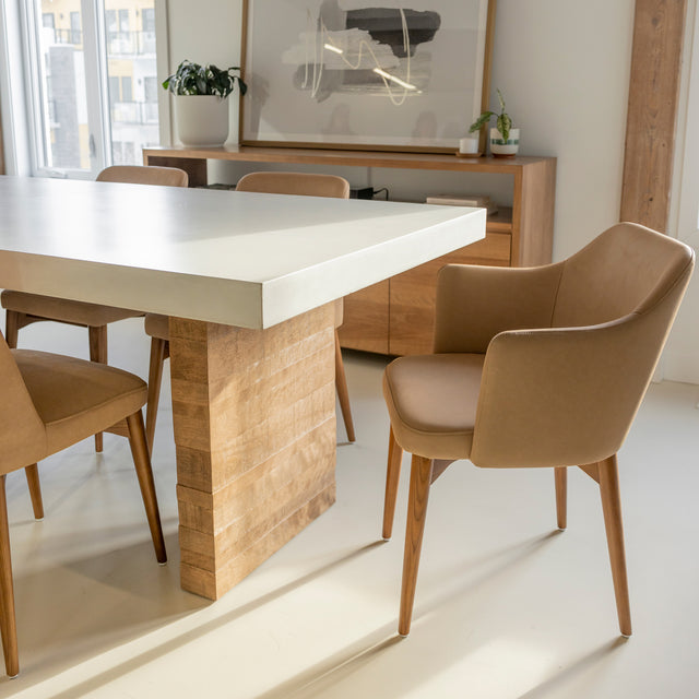 table en beton blanc avec pied en bois massif et chaises beige contemporaines.