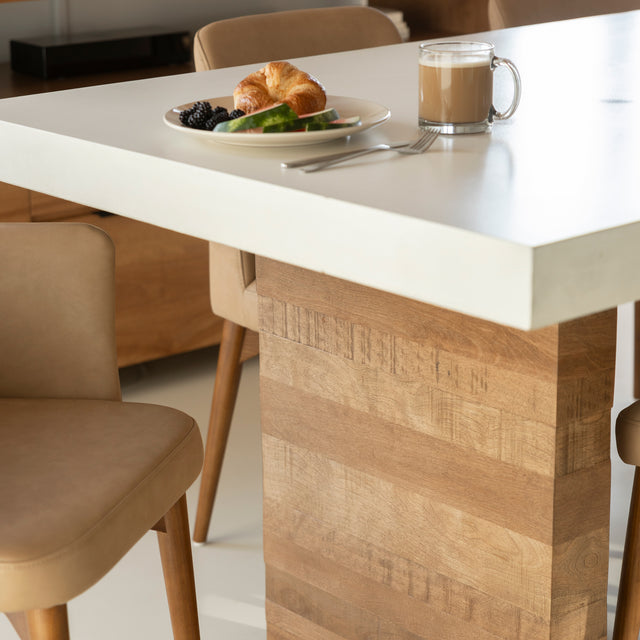 table en beton blanc avec base en bois clair et chaises beige elegantes.