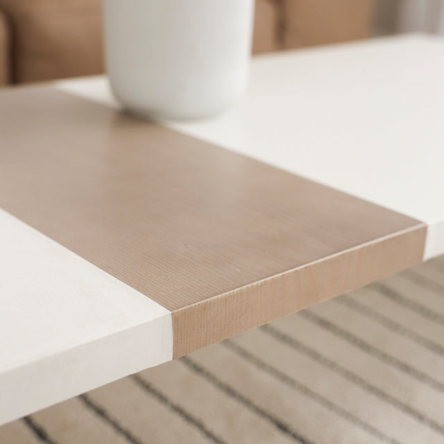 Detail du plateau de table blanche avec insert central en bois clair.