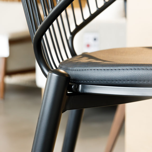 Tabouret de bar noir avec assise rembourrée et dossier ajouré design, idéal pour cuisine moderne.