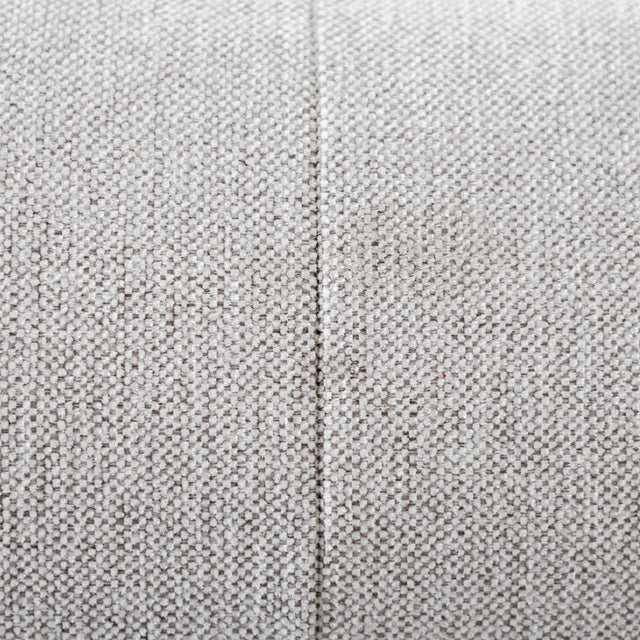 Gros plan sur le tissu texturé beige clair du canapé, montrant la finesse du tissage.