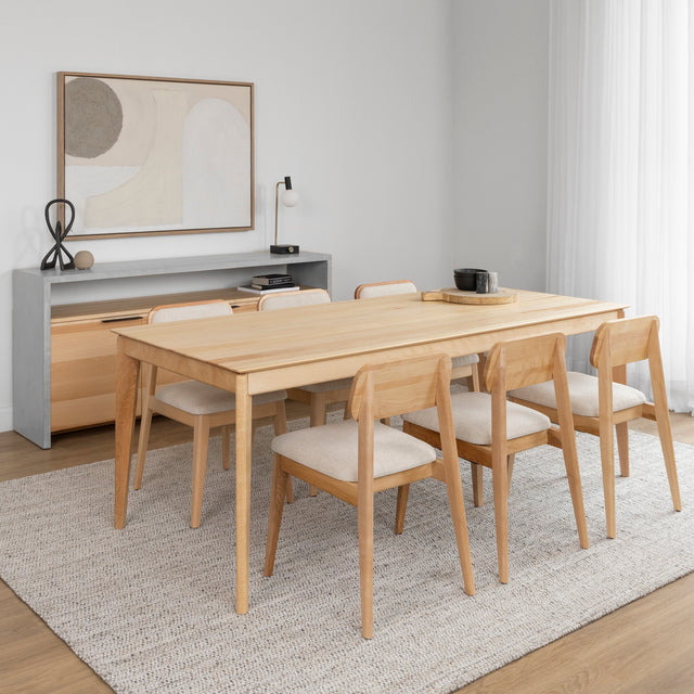 Table a manger en bois clair avec six chaises assorties dans une salle au style scandinave.