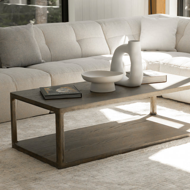 Table basse en bois style minimaliste devant canape beige avec livres et deco moderne.