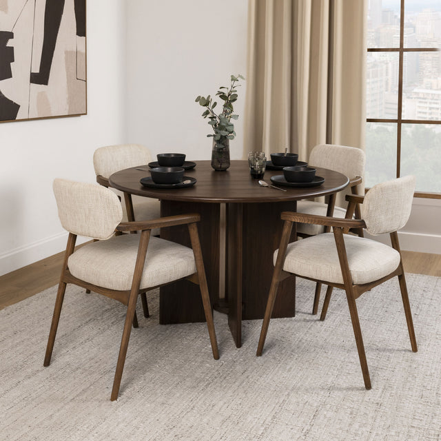 Table à manger ronde en bois foncé avec fauteuils bouclés beige style scandinave.