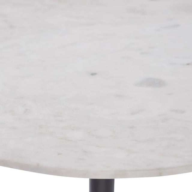 Gros plan sur un plateau rond en marbre blanc veiné, appartenant à une table d’appoint au design épuré.