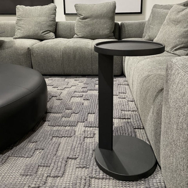 table d'appoint rond noir en metal au design minimaliste.