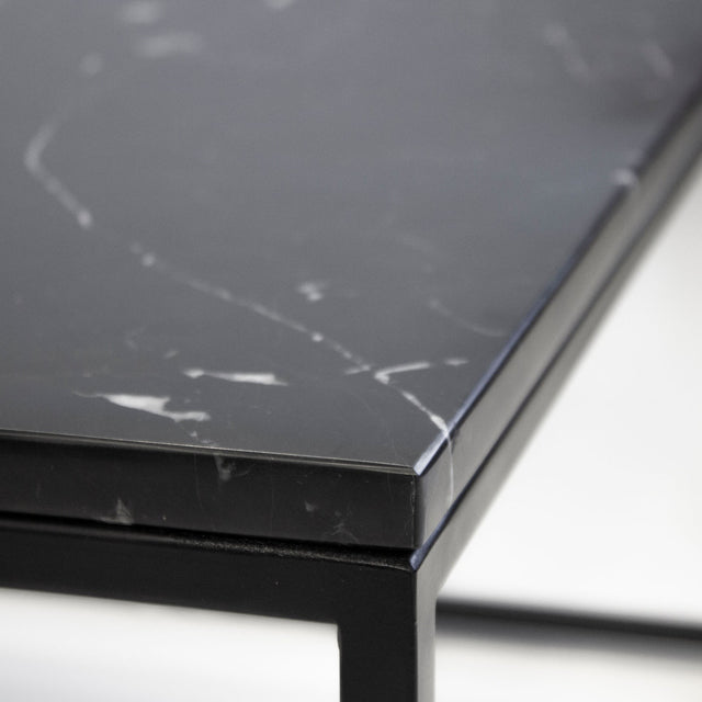 Detail du plateau noir effet marbre avec structure metal noir de table basse moderne.