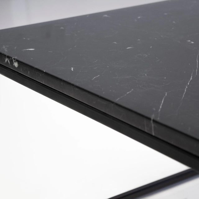 Gros plan sur plateau noir effet marbre avec veines blanches de table basse design.