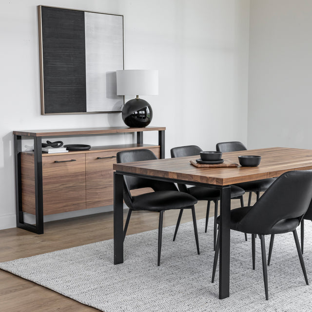 Table en bois noyer avec chaises noires et vaisselle sombre sur planche decorative.