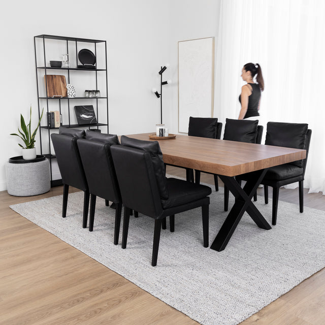 Salle a manger contemporaine avec table en bois, chaises noires et deco minimaliste sur tapis gris.