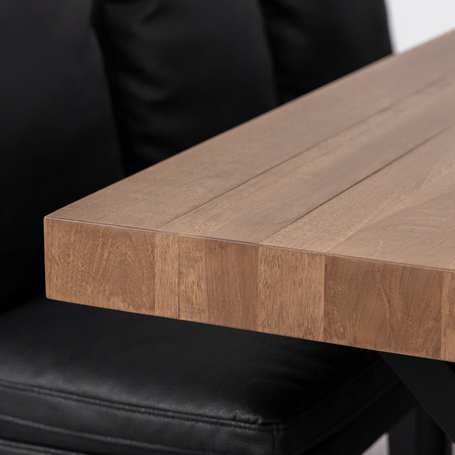 Gros plan sur angle de table en bois massif au fini lisse et naturel.