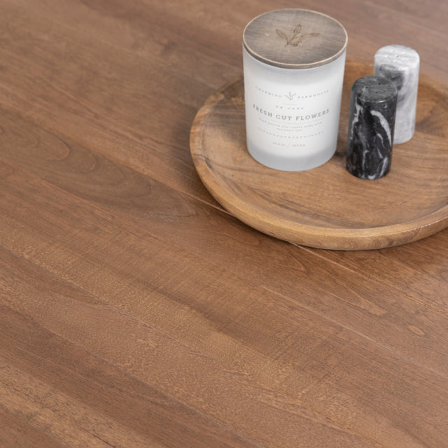 Surface de table en bois avec bougie et accessoires deco sur plateau rond.