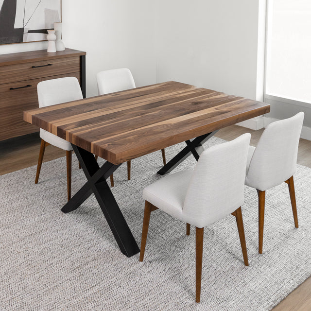 Salle a manger moderne avec table en bois a pieds croises noirs et chaises tissu beige.