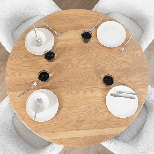 vue du dessus d une table ronde en bois clair avec vaisselle blanche et chaises boucle.