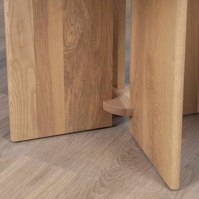 detail du pied central en bois clair de table ronde au design moderne.
