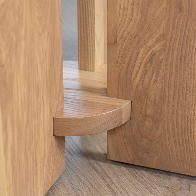 detail du pied central en bois clair de table ronde au design moderne.