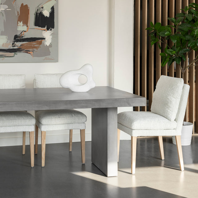 table en beton gris avec chaises blanches et sculpture decorative moderne.