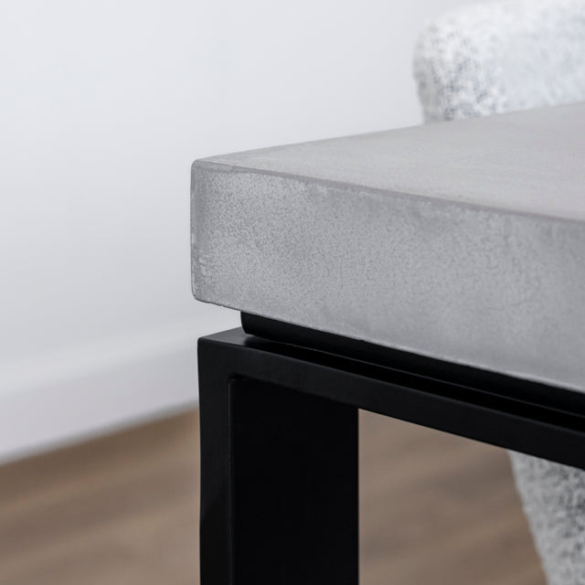 bord de table en beton clair avec structure metallique noire moderne.