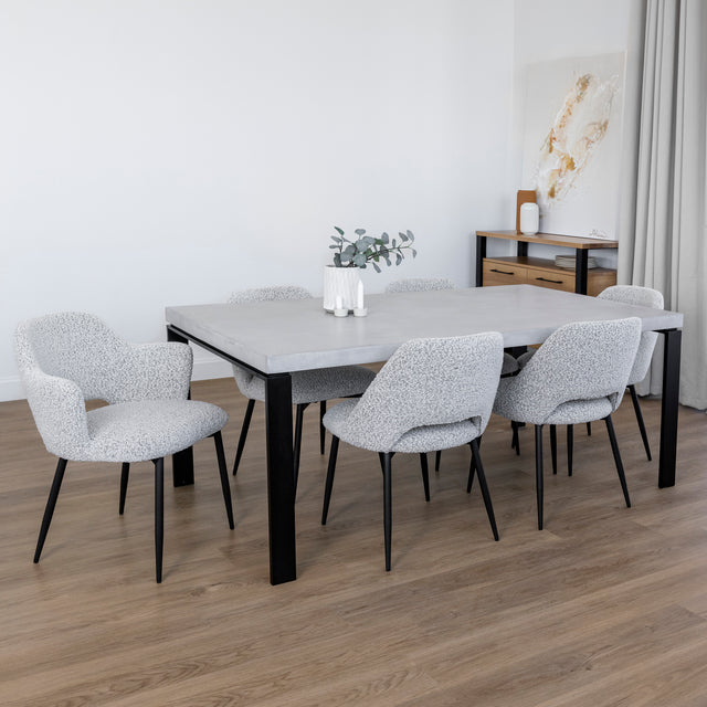 table de salle a manger en beton clair avec chaises grises et deco elegante.