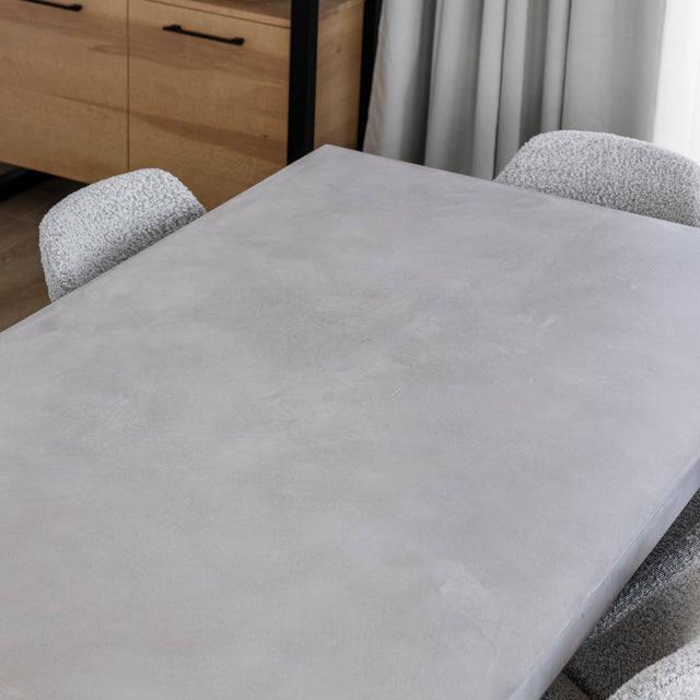 plateau de table en beton clair avec texture lisse et chaises grises.