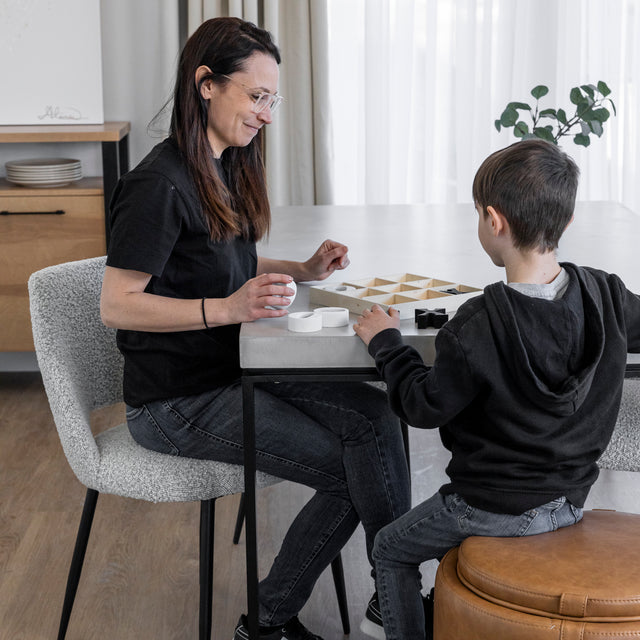 table en beton clair avec chaises grises, scene familiale conviviale.