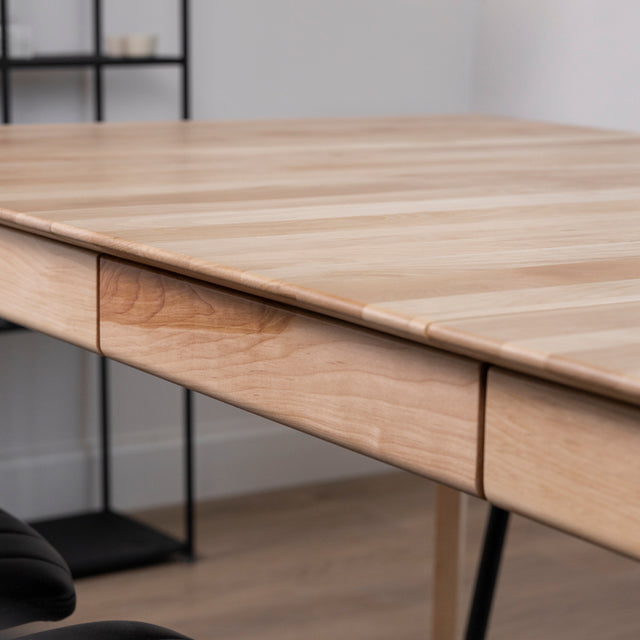 détail du bord et du mécanisme d’extension d’une table en bois clair.
