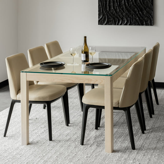 Salle a manger contemporaine avec table en verre et bois clair et chaises beige elegantes.