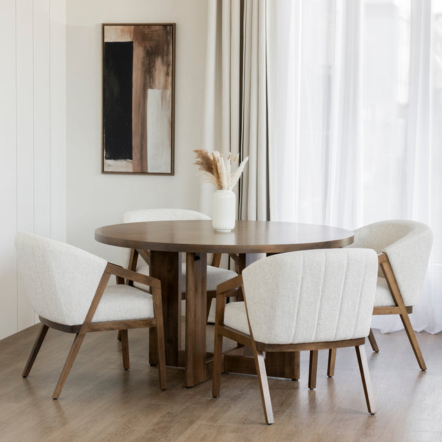 Table ronde en bois avec chaises beige et vase blanc dans deco lumineuse et epuree.