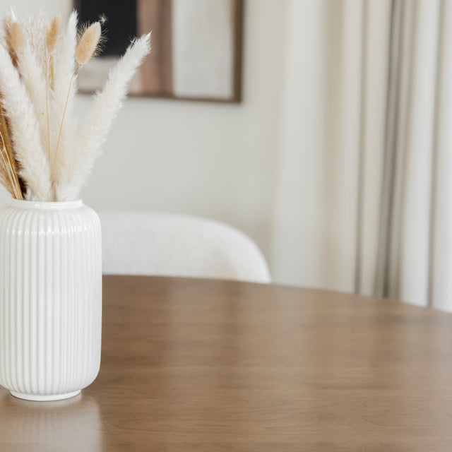Table en bois avec vase blanc et pampas dans une deco douce et naturelle.