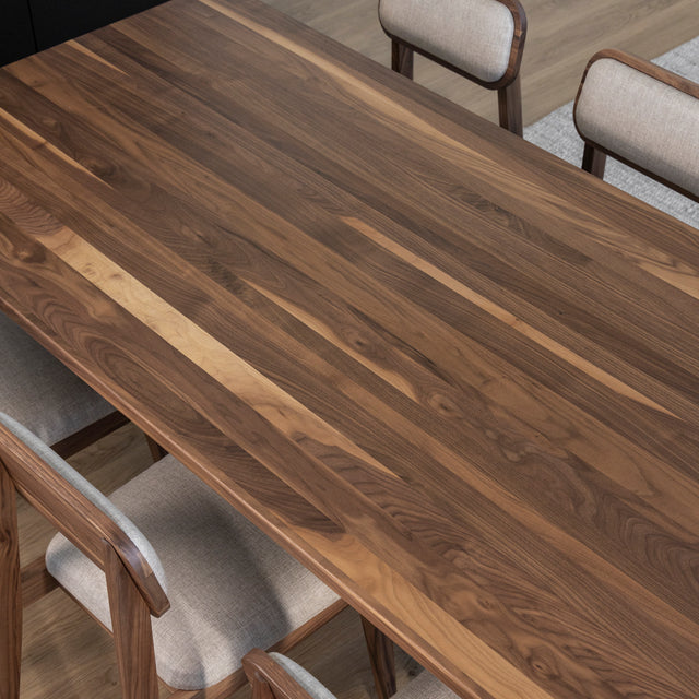 Table en bois noyer avec chaises beiges tapissees sur parquet clair dans decor moderne.