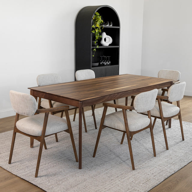 Table a manger en bois noyer avec six chaises tapissees beige sur tapis clair.