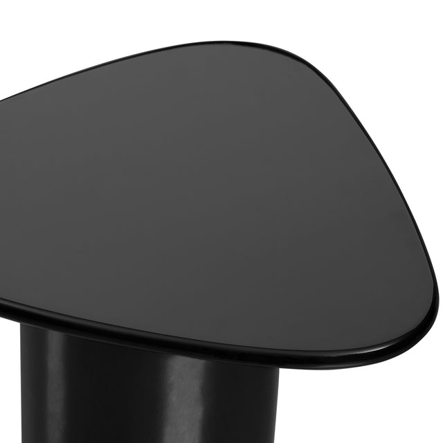 Gros plan sur une table d’appoint noire brillante, montrant son plateau aux bords arrondis et sa base cylindrique lisse.