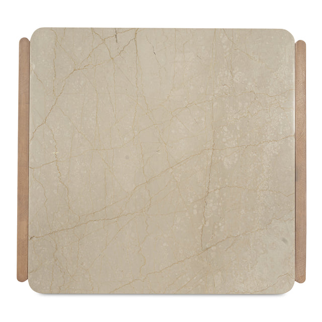 Vue du dessus d’une table basse avec plateau carré en pierre beige veiné et pieds en bois clair.