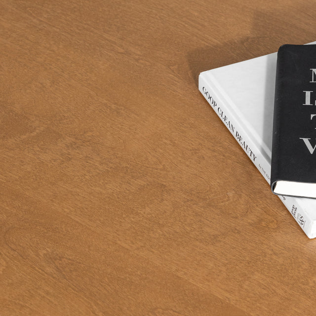 Plateau de table basse en bois clair avec deux livres poses sur la surface.