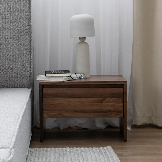 table de chevet en bois noyer avec une lampe blanche