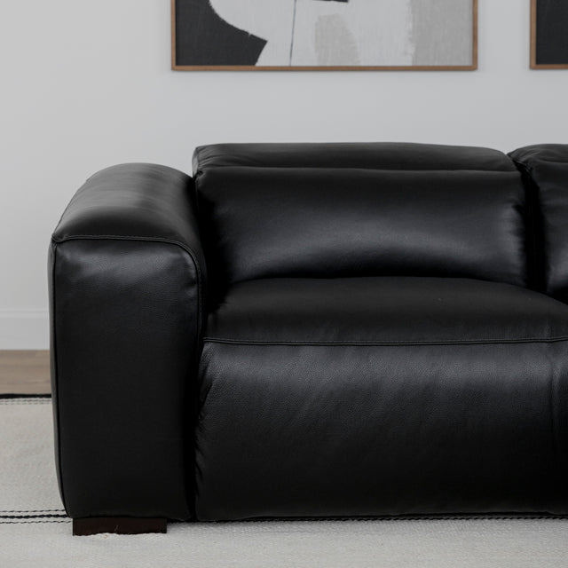 fauteuil en cuir noir au design moderne avec accoudoir large.