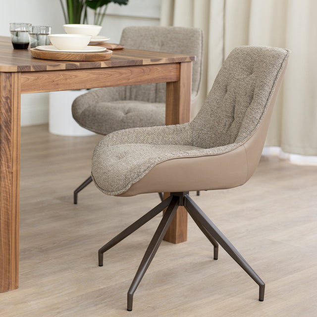 Chaise de salle à manger tissu chocolaté avec piétement en métal bronze, placée près d’une table en bois moderne.