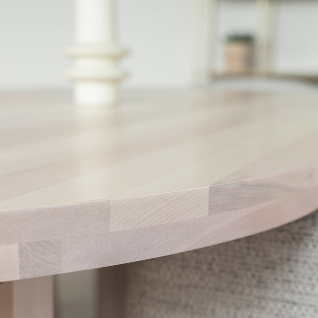 Image rapprochée d'une table ovale en bois clair.