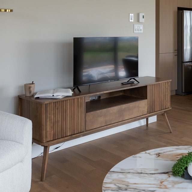 Meuble TV en bois moderne avec rangement et television dans un salon contemporain.