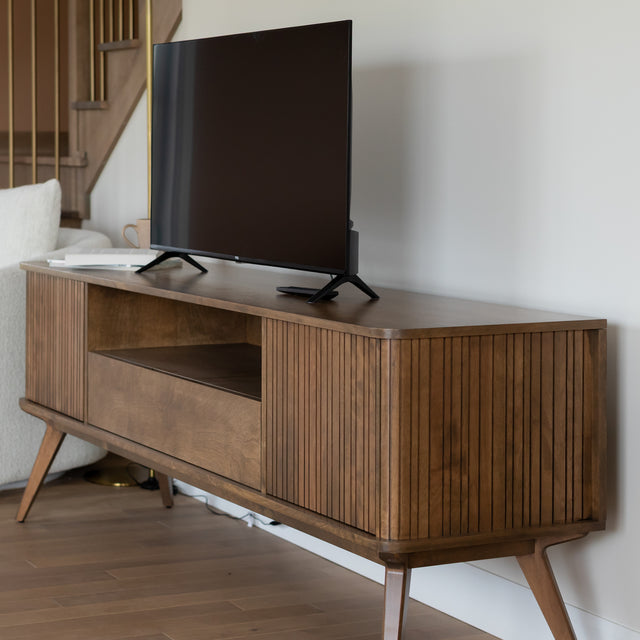 Meuble TV en bois moderne avec rangement et television dans un salon contemporain.