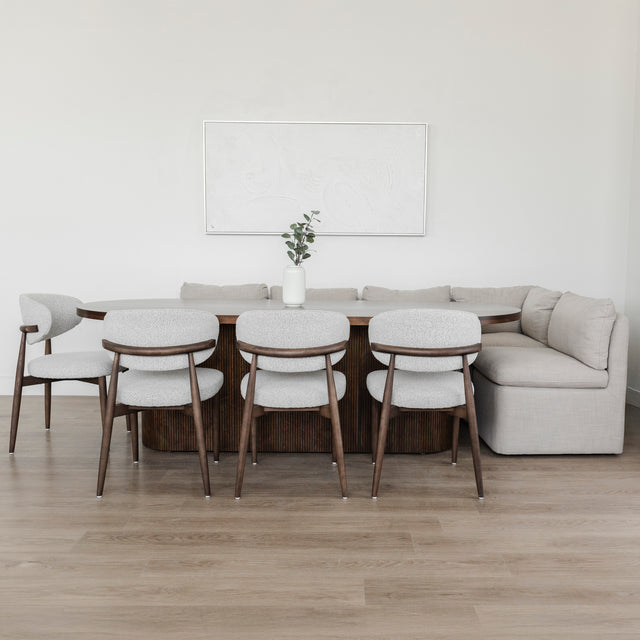 Table ovale en bois fonce avec banquette grise et chaise beige dans deco moderne.