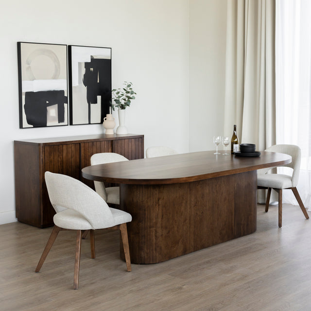 Salle a manger elegante avec table ovale en bois fonce et chaises beige modernes.