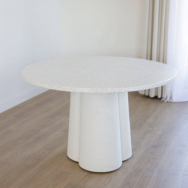 table ronde blanche au plateau en terrazzo et base sculpturale.